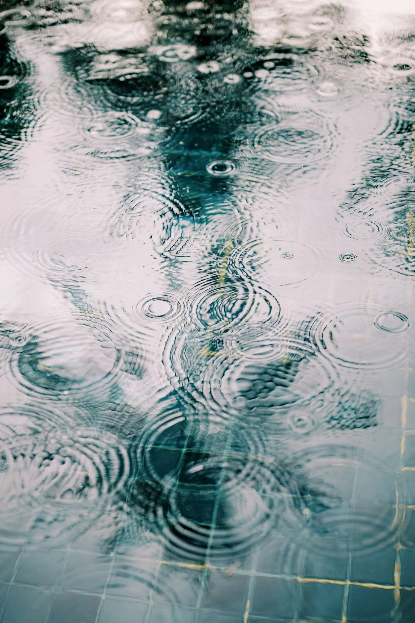 Raindrops creating reflections in the pool at Amanpuri in Phuket, Thailand