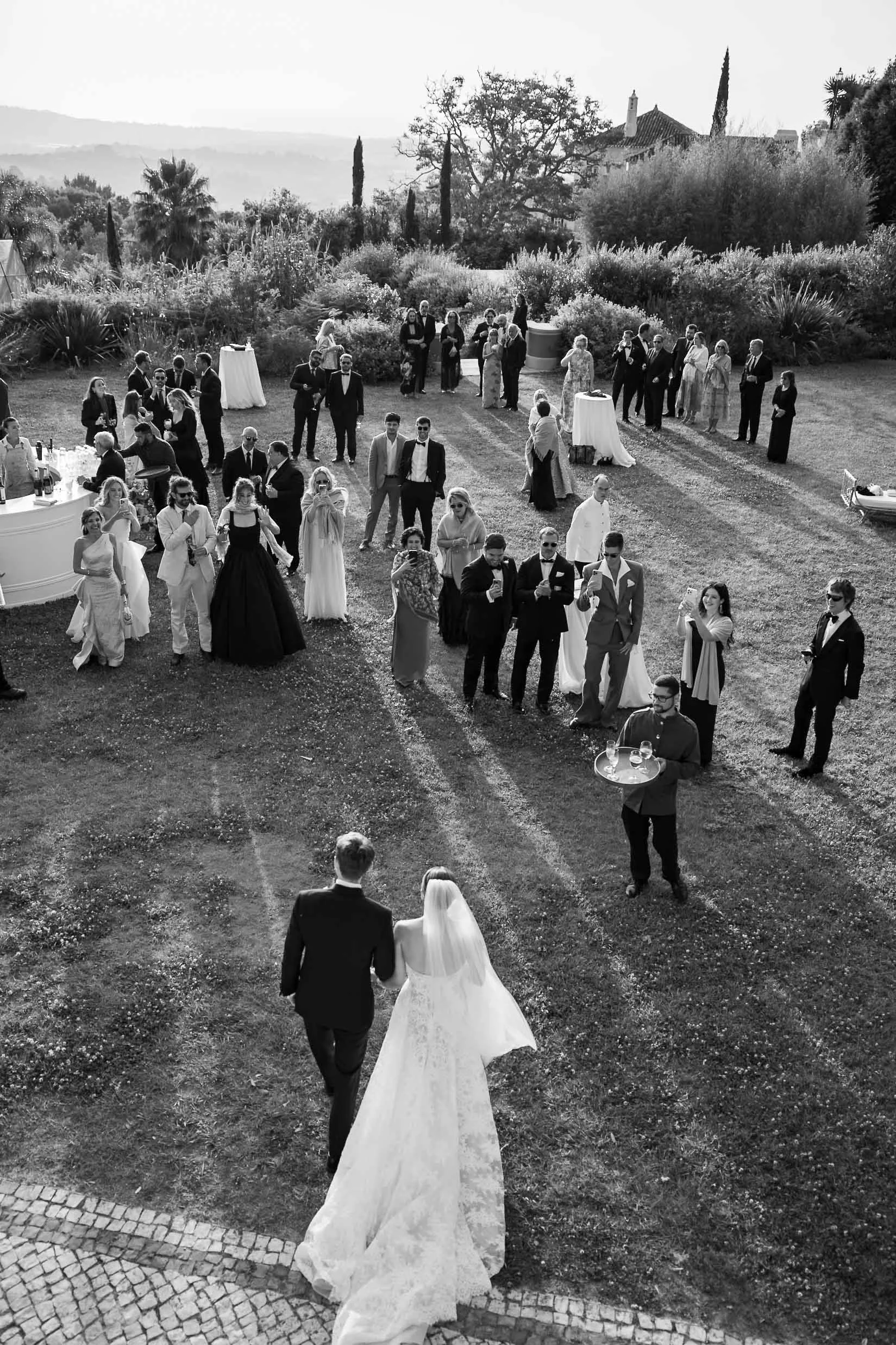 Bride and groom walking toward their guests during an outdoor wedding celebration