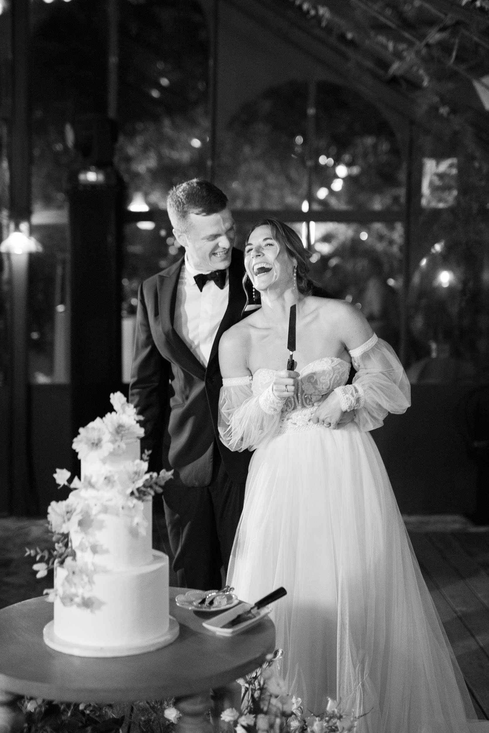 Bride and groom smiling by the wedding cake during the reception at Quinta da Bella Vista in Sintra, Portugal