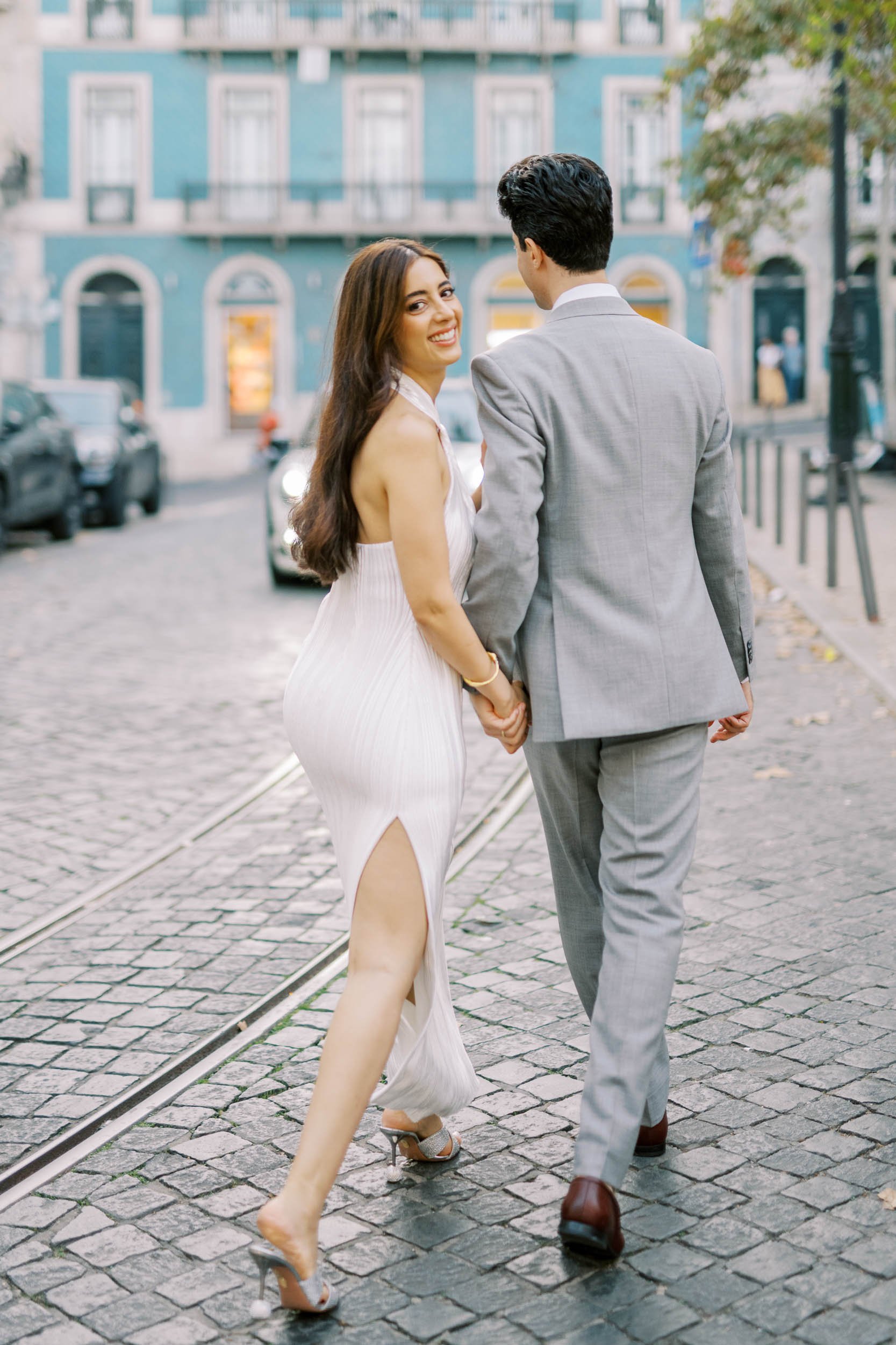 Couple walking through the streets of Lisbon during an engagement session in Portugal