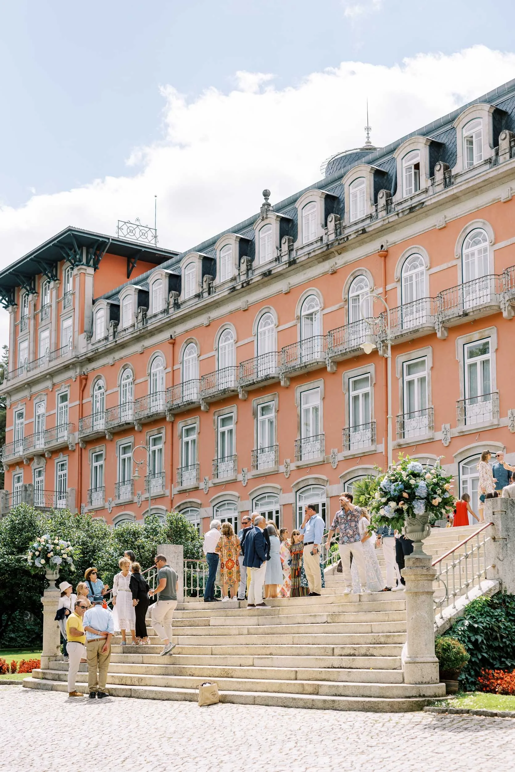 Wedding guests on the exterior staircase of Vidago Palace Hotel in Portugal