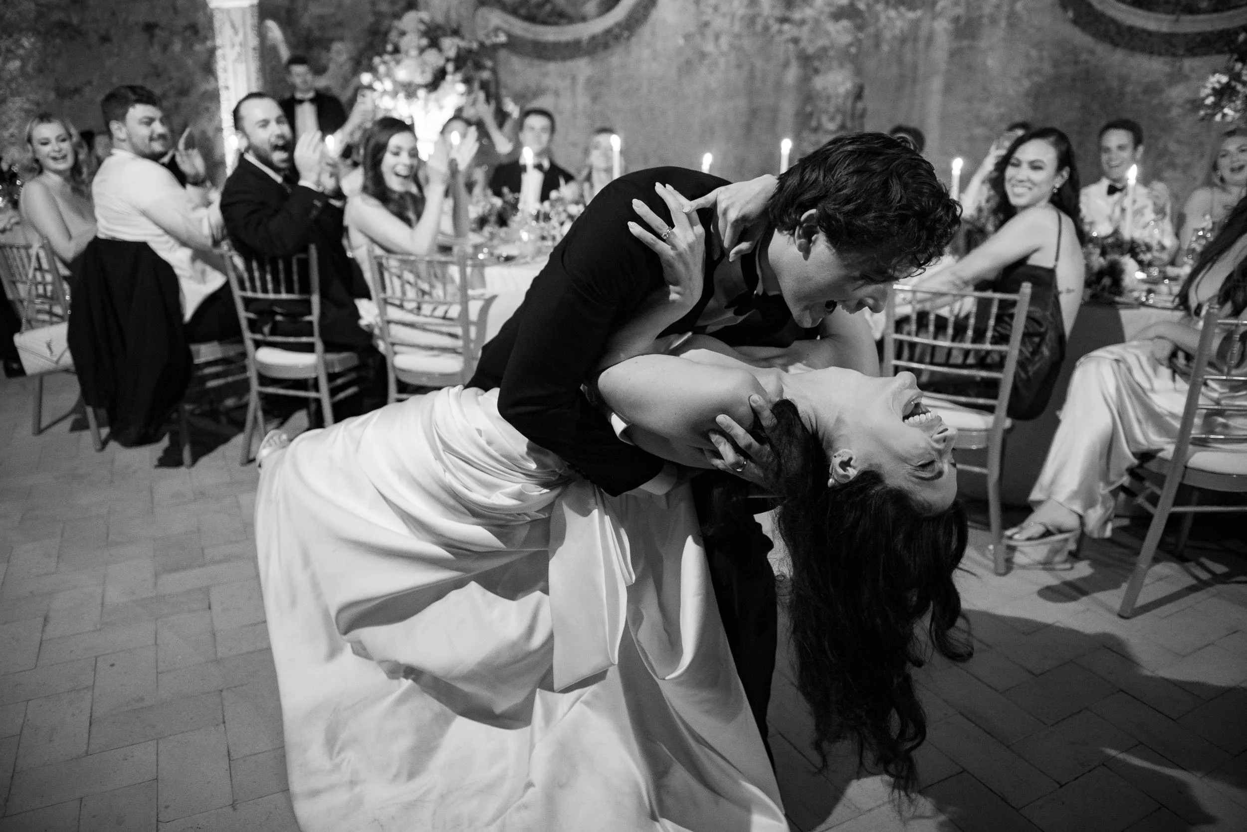 Bride and groom kissing on the dance floor with guests watching at Casa dos Penedos in Sintra