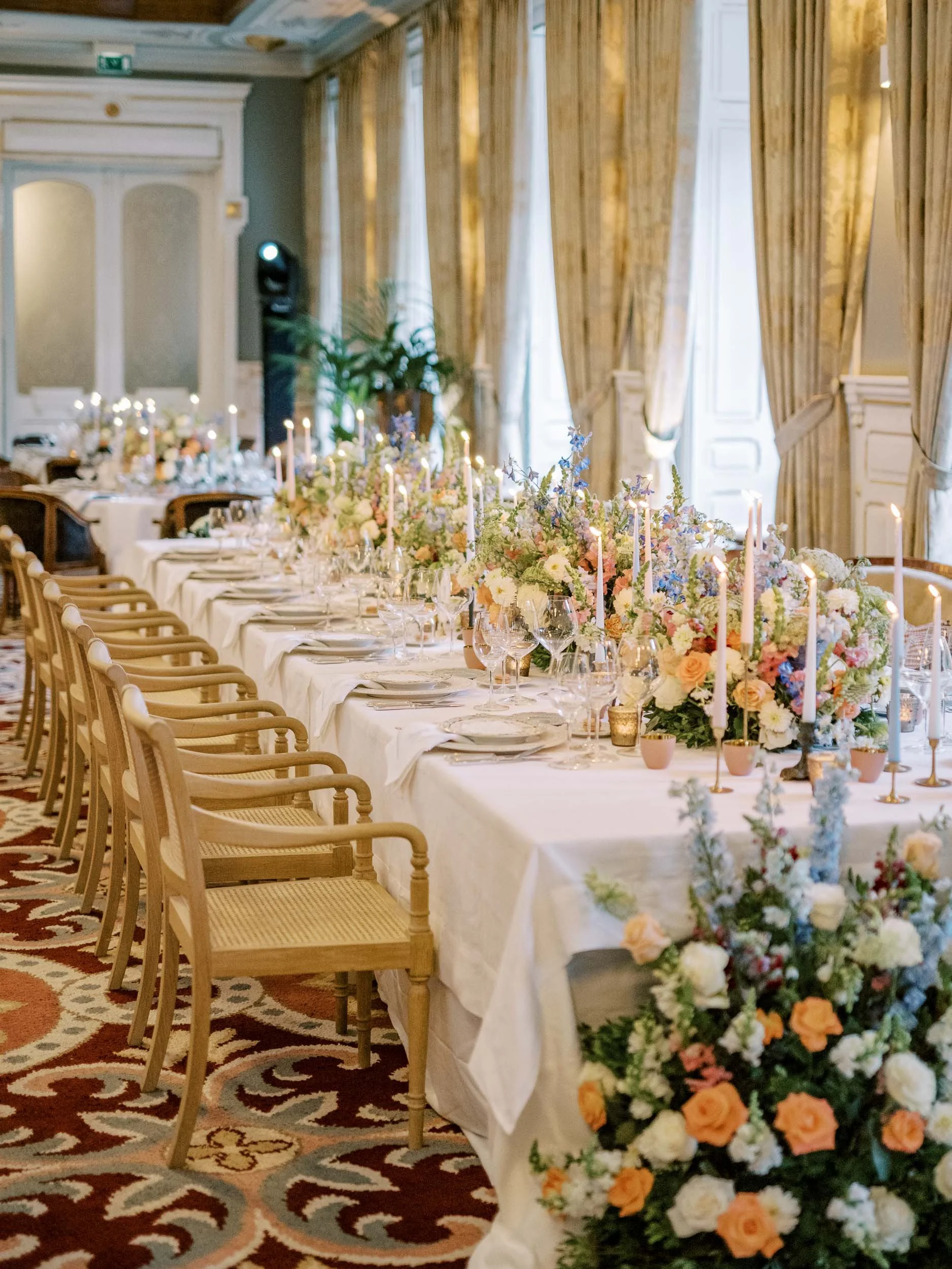 Reception table styling with floral arrangements during a wedding at Vidago Palace Hotel in Portugal
