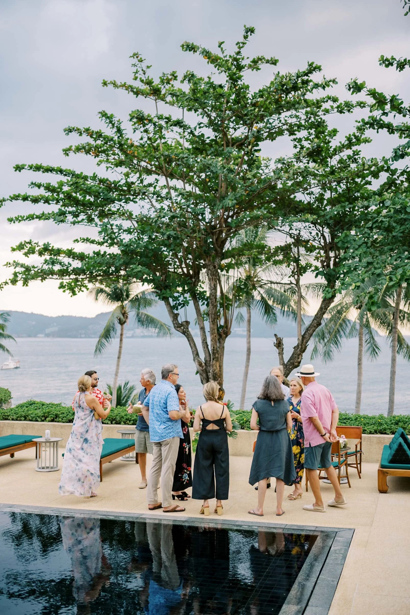 Guests gathering by the pool during the welcome celebration at Amanpuri in Phuket, Thailand