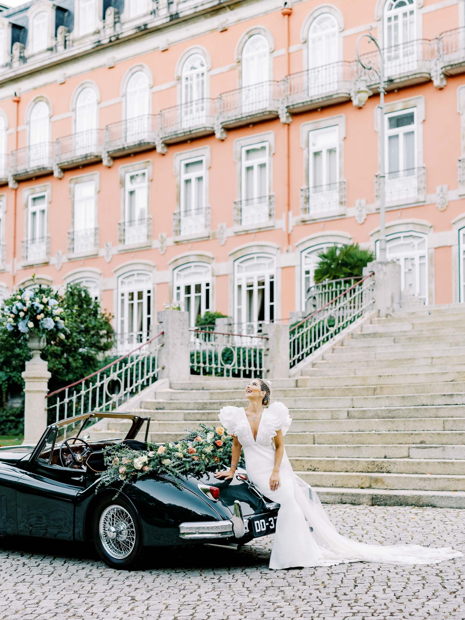 Bride portrait by the car outside Vidago Palace Hotel during a wedding in Portugal