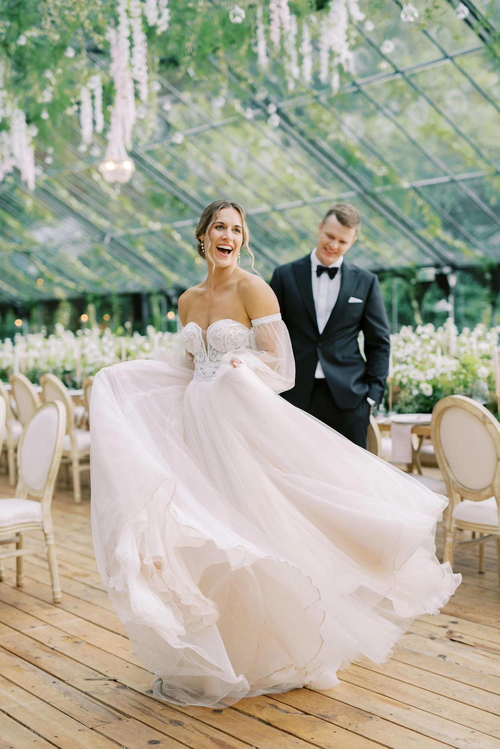 Bride dancing with the groom behind her in the Glass House at Quinta da Bella Vista in Sintra, Portugal