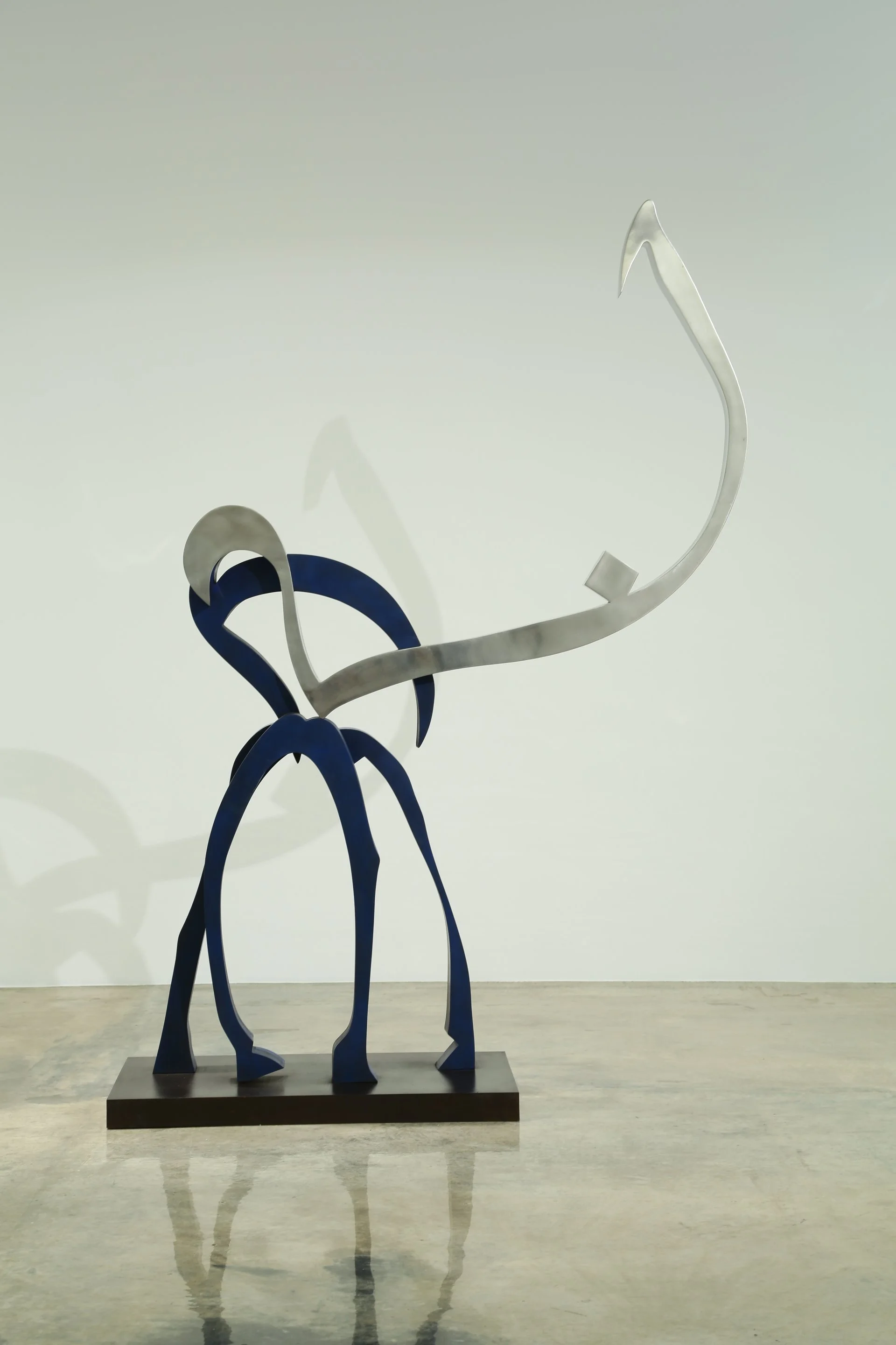 Abstract metal sculpture resembling an insect or alien creature with long legs, a curved body, and antennae, displayed on a black base against a plain background.