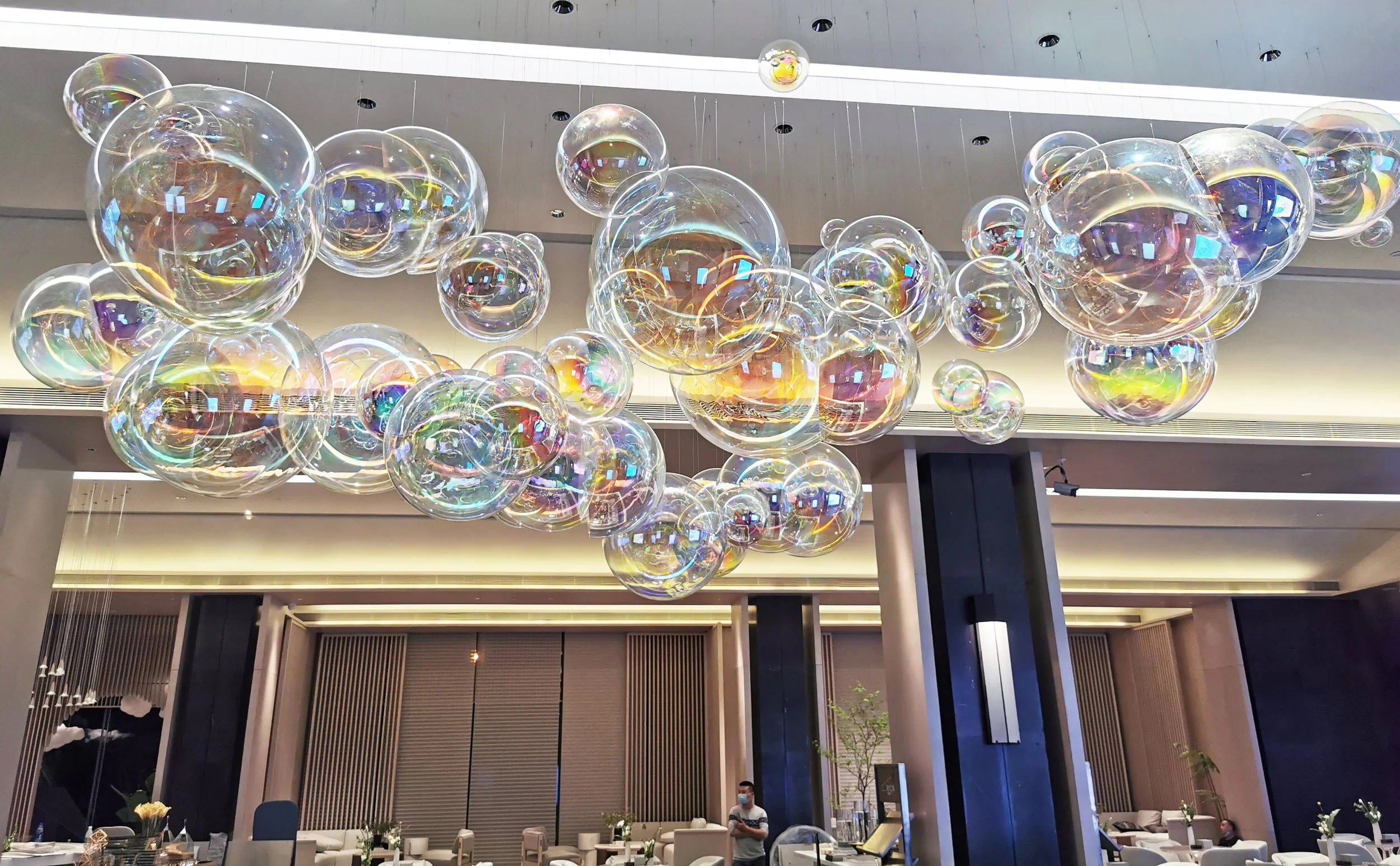 Times of City Chongqing acrylic ball art installation with electroplated finish and LED spotlights, fabricated through cutting and color treatment, delivered through design development, production, and installation by Core Art Strategies.