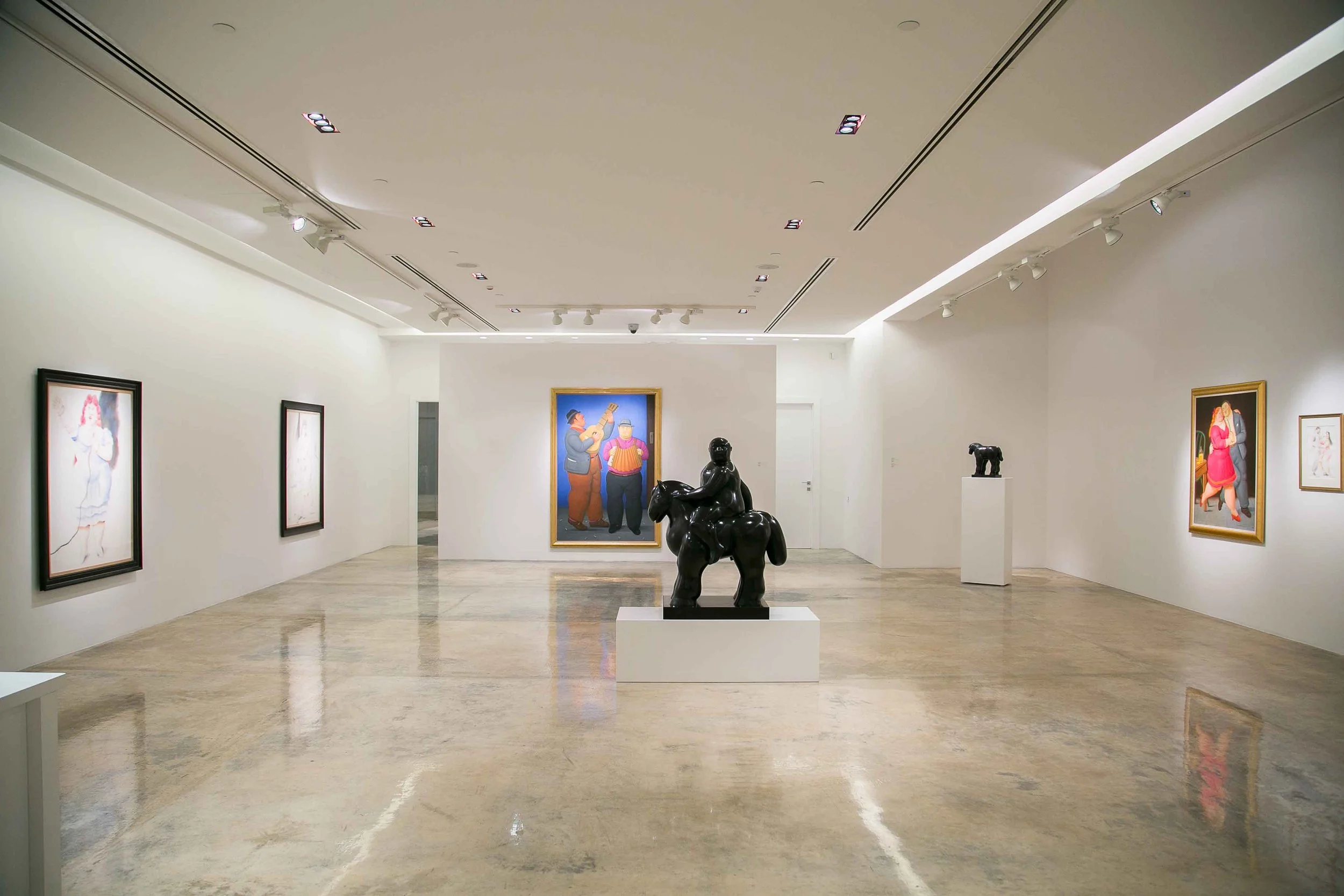 Visitors interacting with a Fernando Botero painting in an exhibition curated by Mohamad Ali Makouk at Anima Gallery