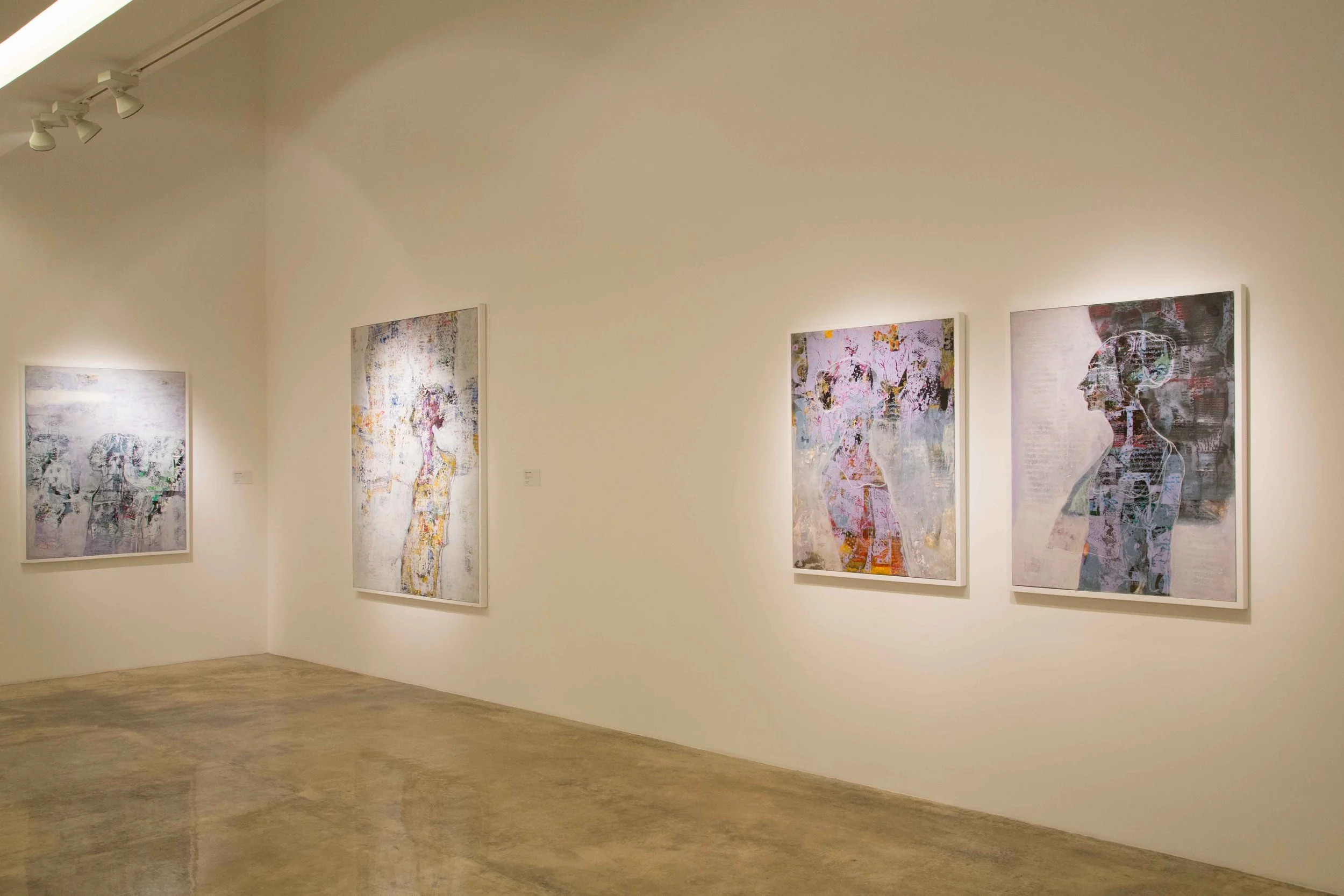 Art gallery interior with four abstract paintings of female figures on white walls, illuminated by track lighting.