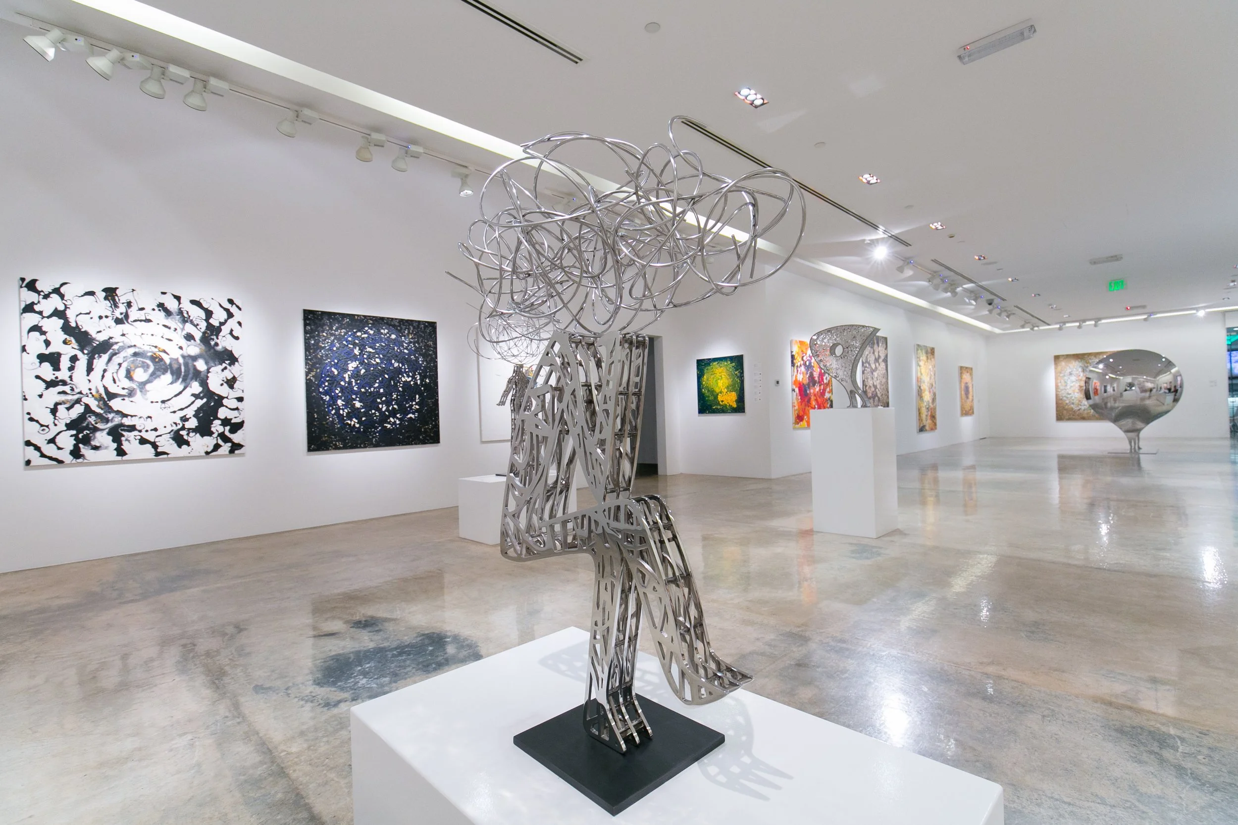 Gallery visitors view artworks during a Nadim Karam exhibition in Qatar, curated by Mohamad Makouk as part of Core Art Strategies’ contemporary art practice.