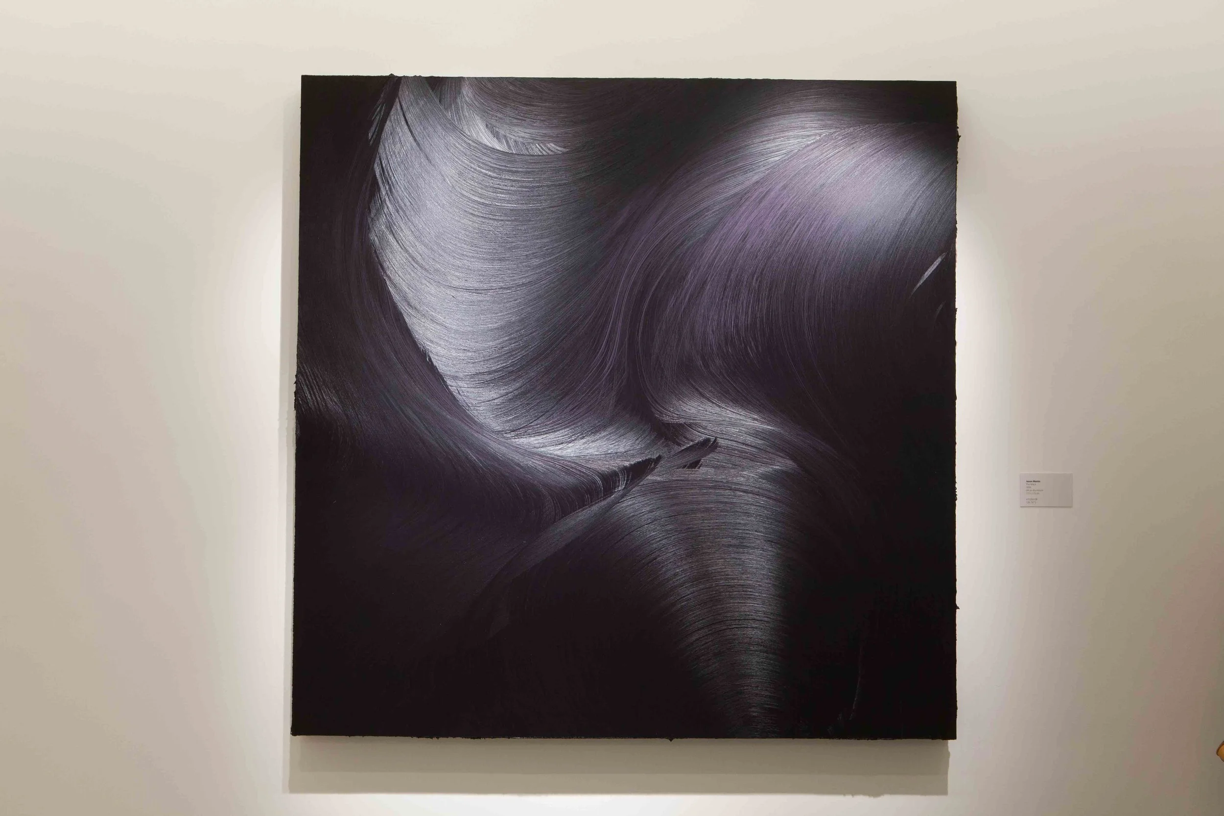 Abstract painting with sweeping black and purple brushstrokes on canvas displayed on white gallery wall.