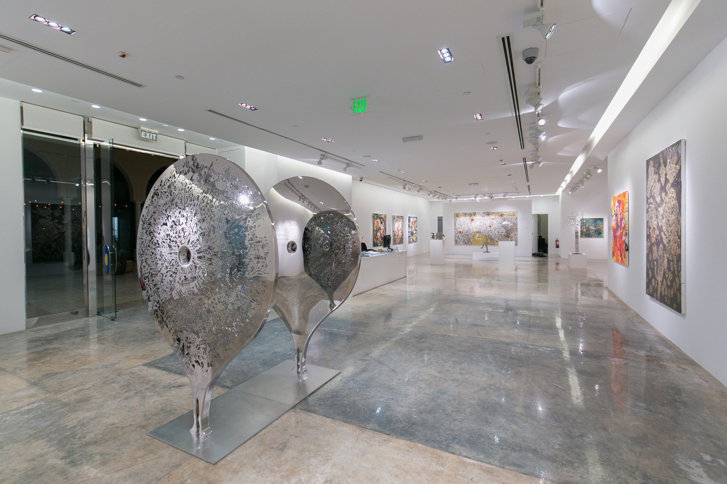 Art collectors and visitors explore a Nadim Karam exhibition in Qatar, presented through a curated contemporary art experience by Core Art Strategies.
