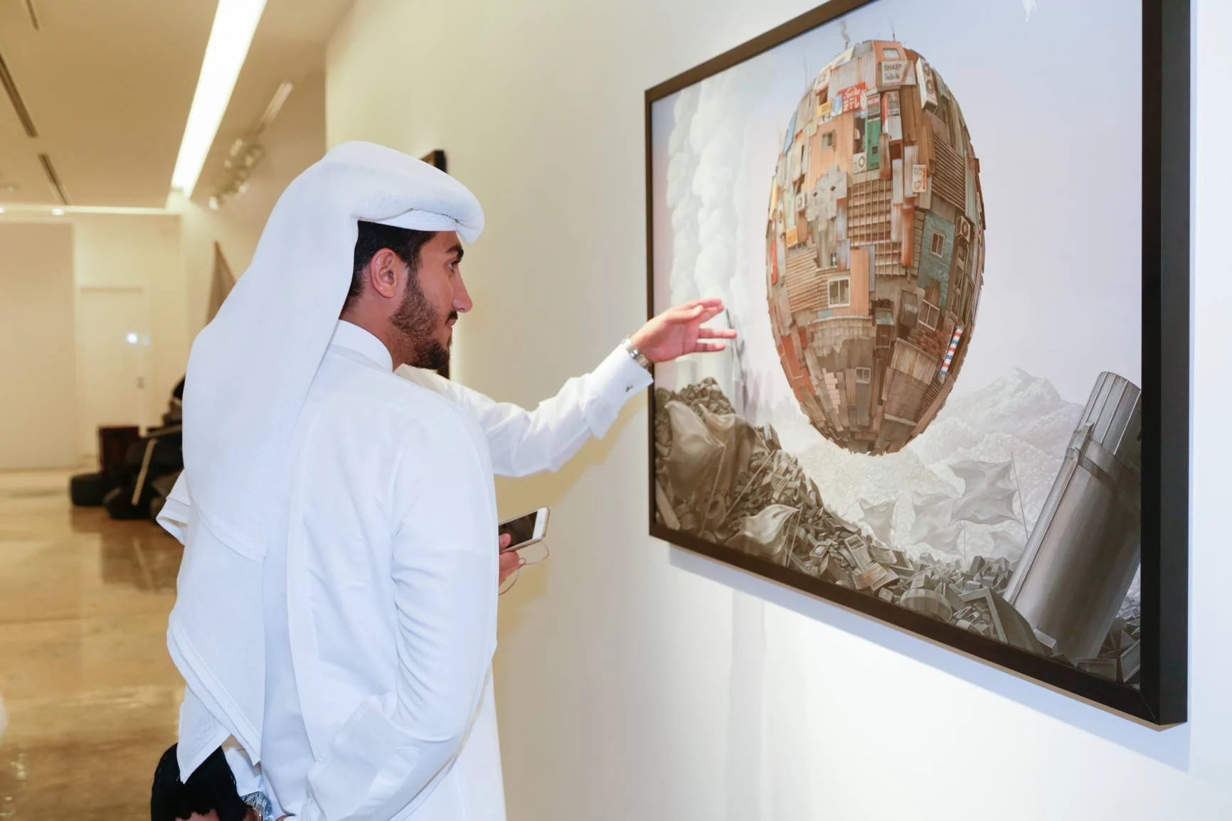 Man in traditional Middle Eastern attire viewing surreal artwork of a floating city on a wall-mounted digital display.