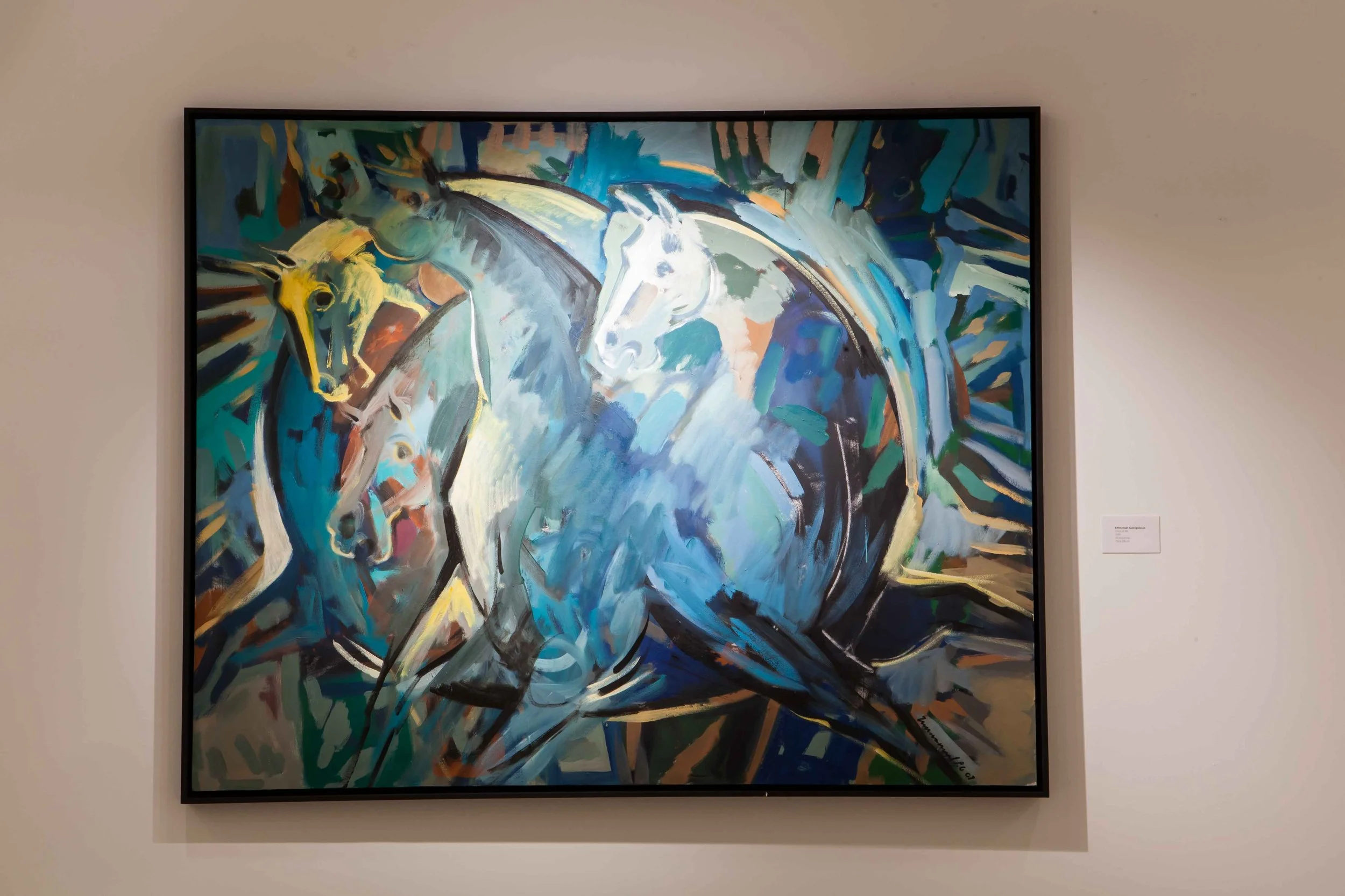 Abstract painting of white horses, with streaks of green, blue, yellow, and black, on a gallery wall.