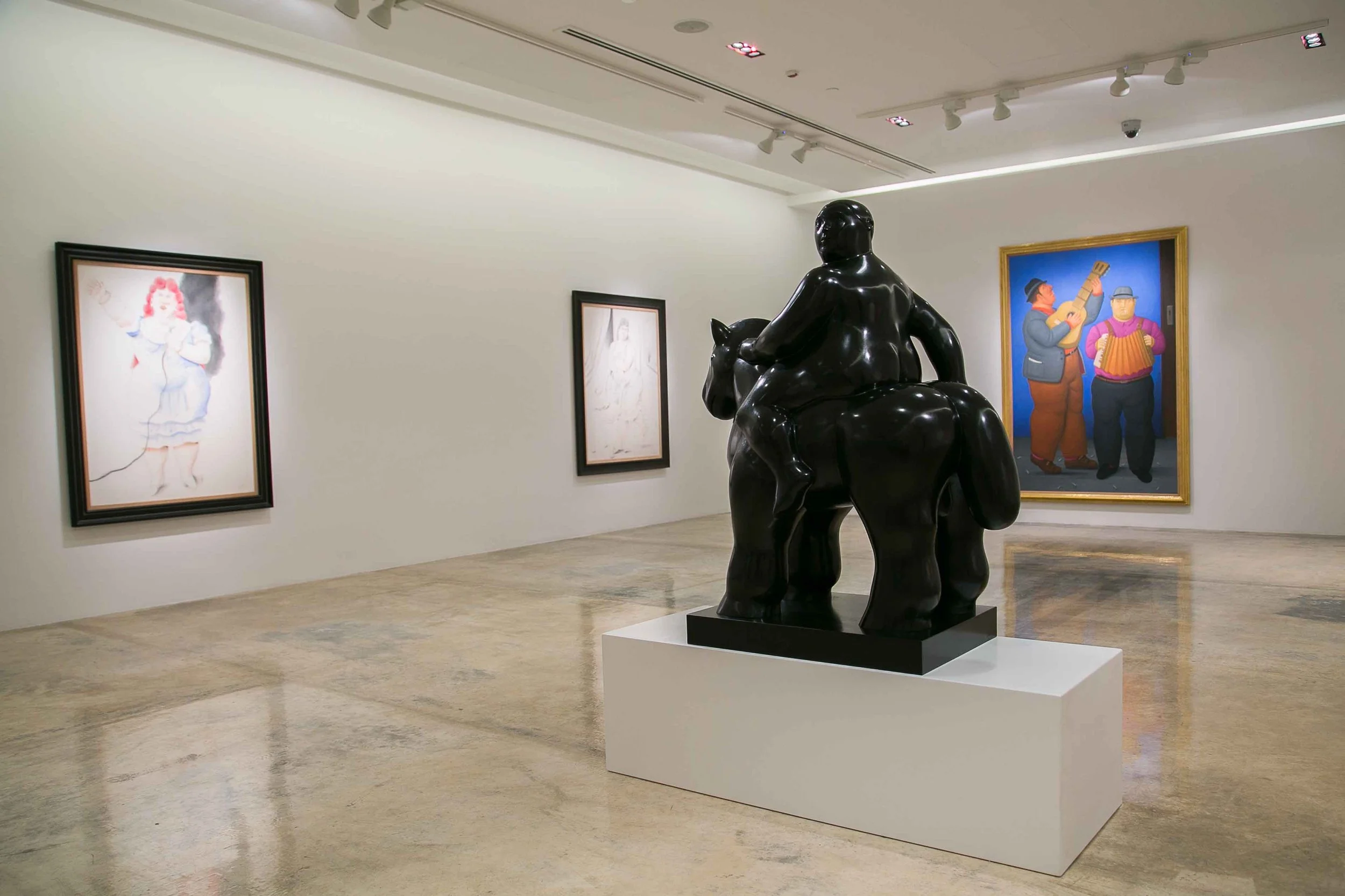 Visitors viewing a painting by Fernando Botero in an exhibition curated by Mohamad Ali Makouk in Qatar