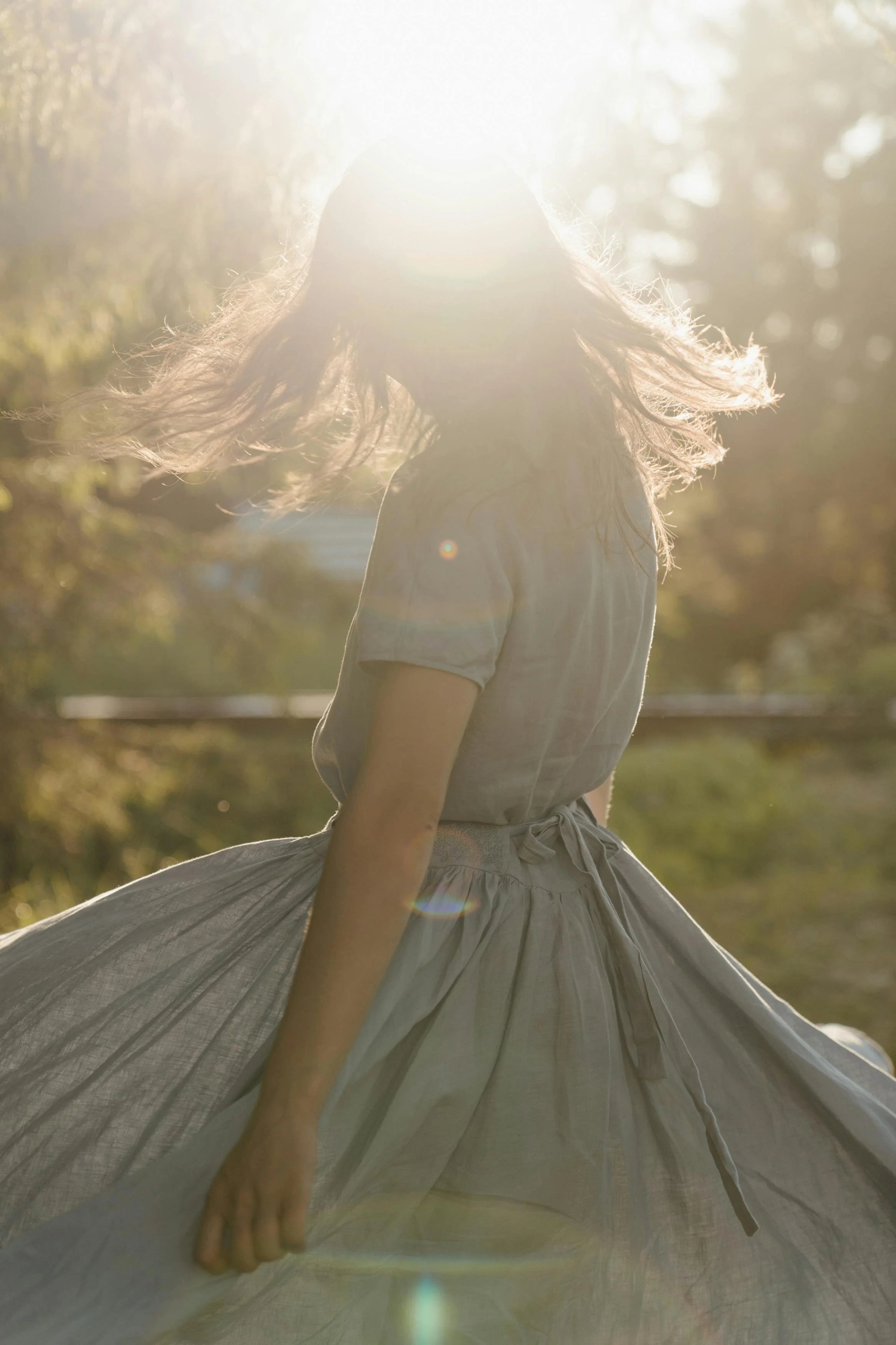 Woman outdoors in sunlight, representing warmth and approachability in therapy