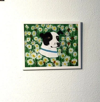 Cali Among the Daisies, a 12 x 15f original acrylic dog portrait by Bonnie Seide displayed on a wall.