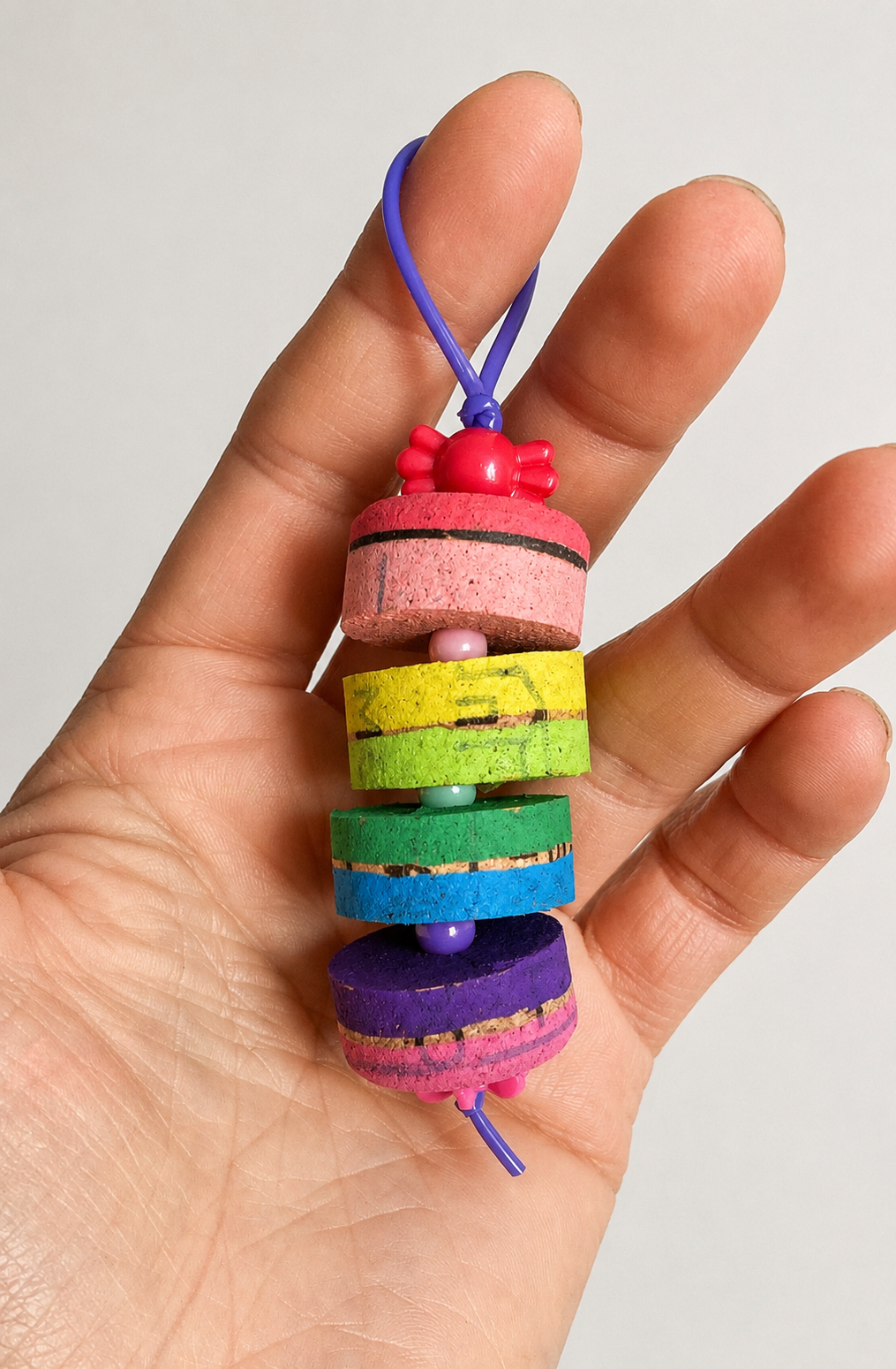 Braccialetto di gomma colorata con elementi di varie forme e colori, con cordino viola