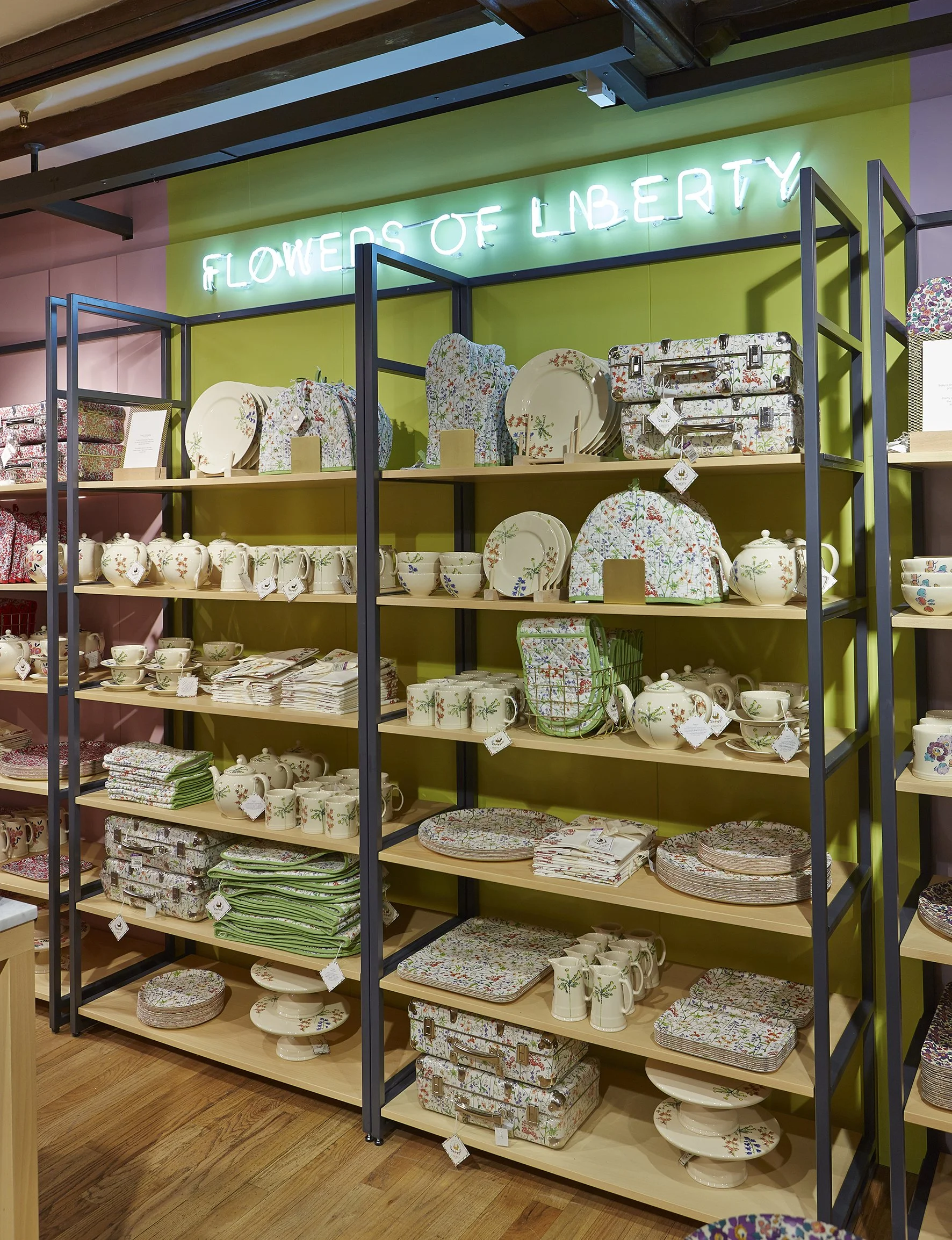 Display of ceramic dishware and kitchen textiles on shelves in a store.