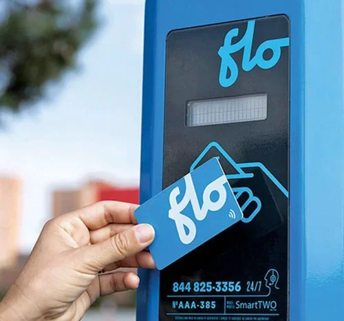 Close-up of a hand inserting a Bla (flo) card into a contactless payment terminal.