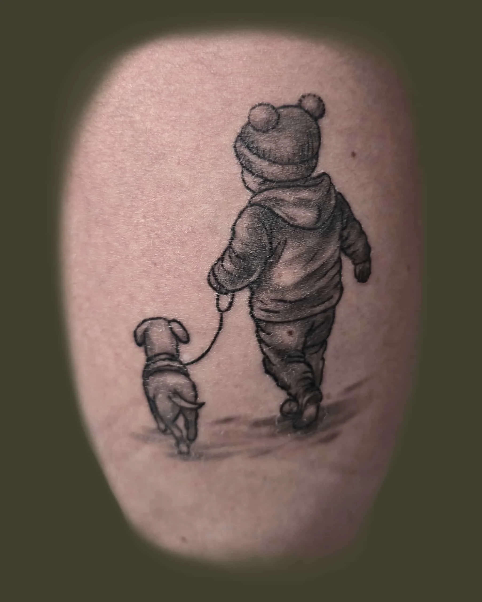 Mustavalkoinen tatuointi, jossa kävelee lapsi ja koira
