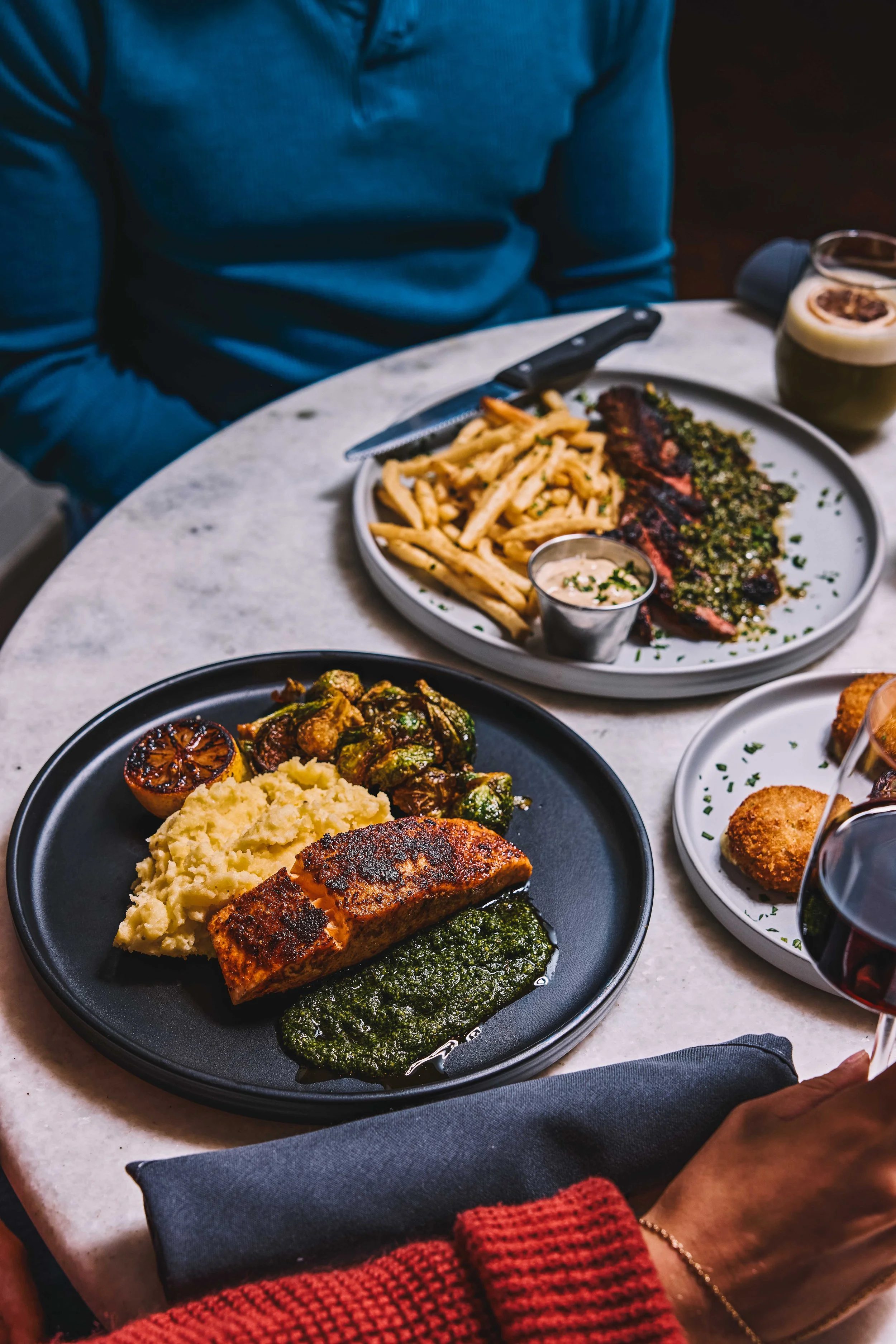 steak frites pesto salmon on a marble table
