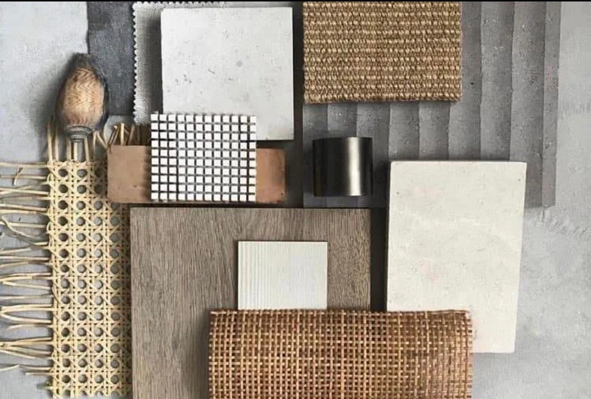 Collection of fabric and material sample swatches on a surface, including woven, textured, and smooth samples in various colors and patterns.