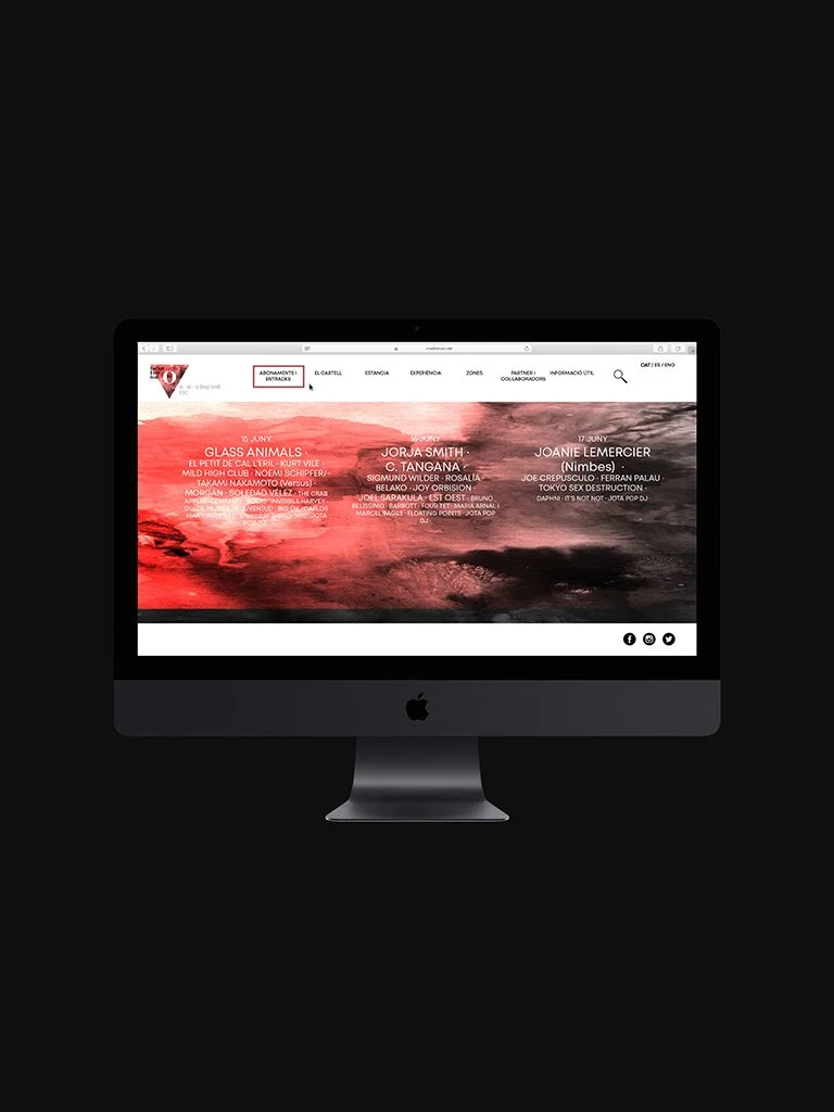 Graphic design. End-of-degree project. A computer monitor displaying a website with a red and black abstract background and white text, on a black background.
