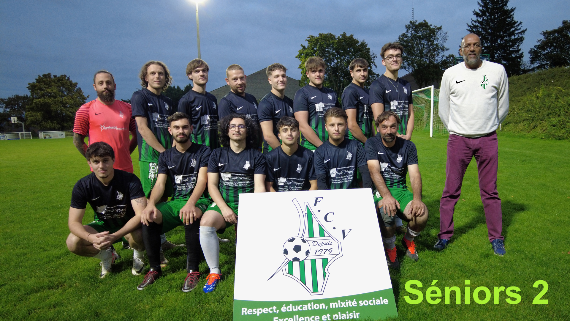Photo d'une équipe de football avec 13 hommes, dont certains en tenue et d'autres en tenue d'entraînement, sur un terrain de football en extérieur avec un panneau affichant le logo du club FC, datant de 1979, et le slogan "Respect, éducation, mixité sociale, Excellence et plaisir". Tony, un homme en blanc, se tient à droite, et le texte "Séniors 2" apparaît en bas à droite.