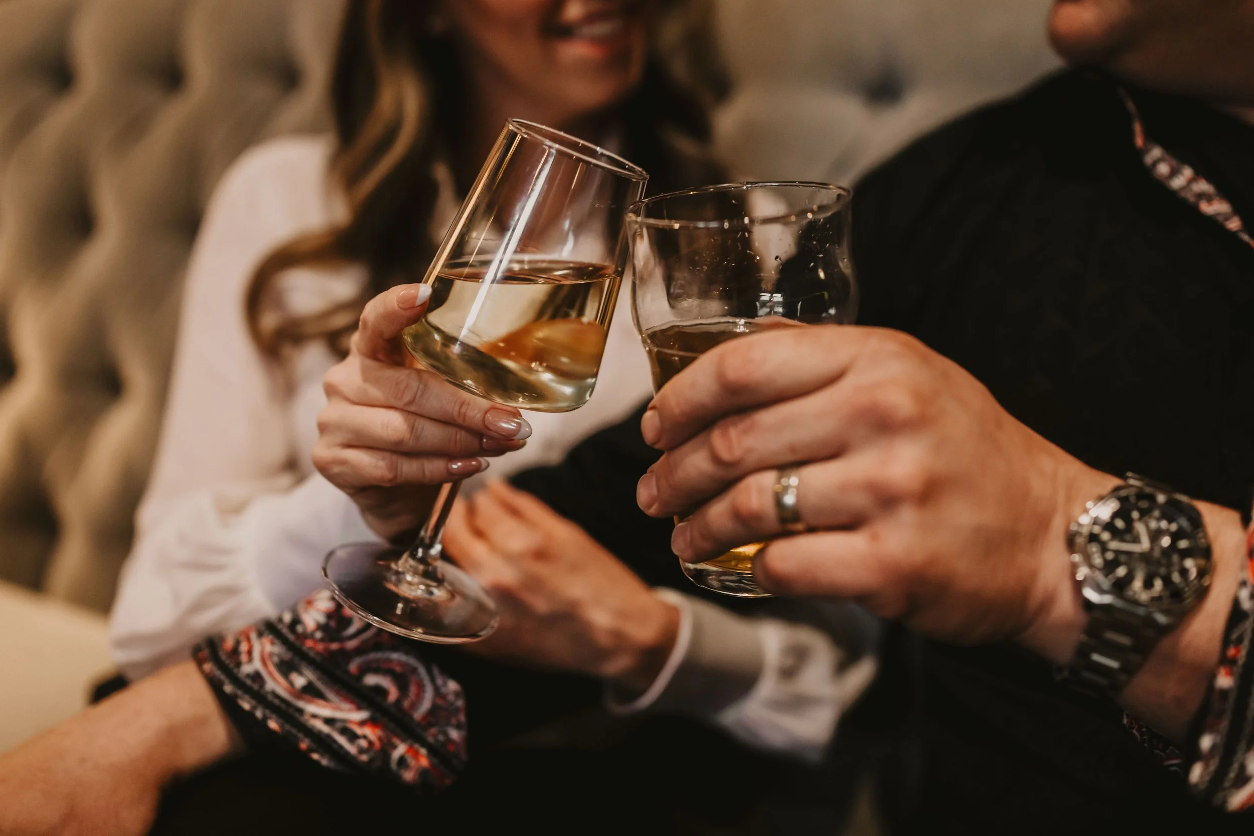 Couple toasting with wine glasses in an intimate lounge setting at Sir Sanford Loft On Main in Collingwood