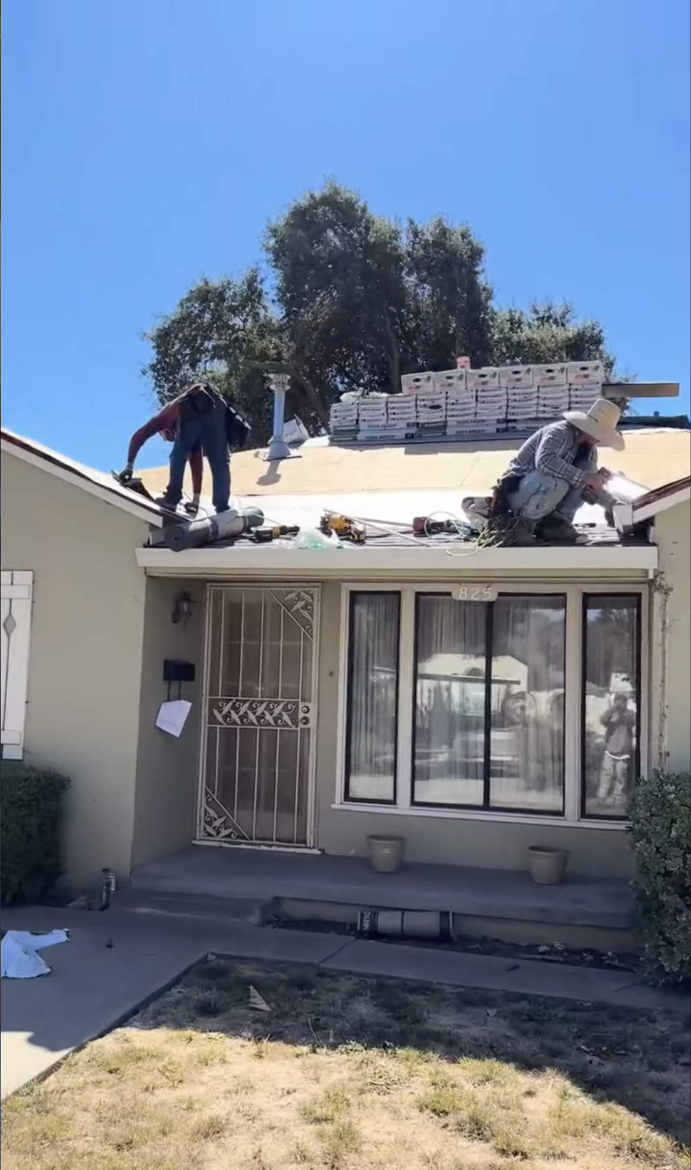 Two workers installing a new roof on a residential house in Hollister, CA.
