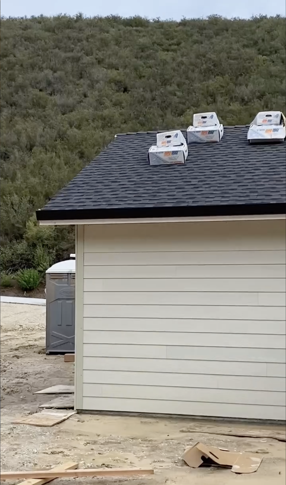 A house with beige siding and a dark shingled roof under construction in Gilroy, CA.