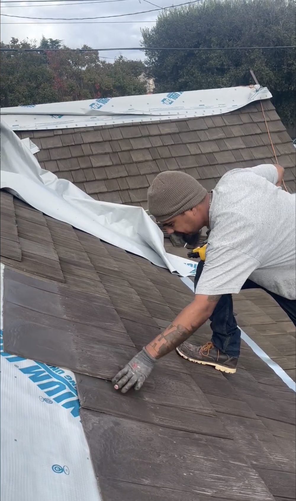 A man installing or repairing a shingle roof on a house in Hollister, CA. 