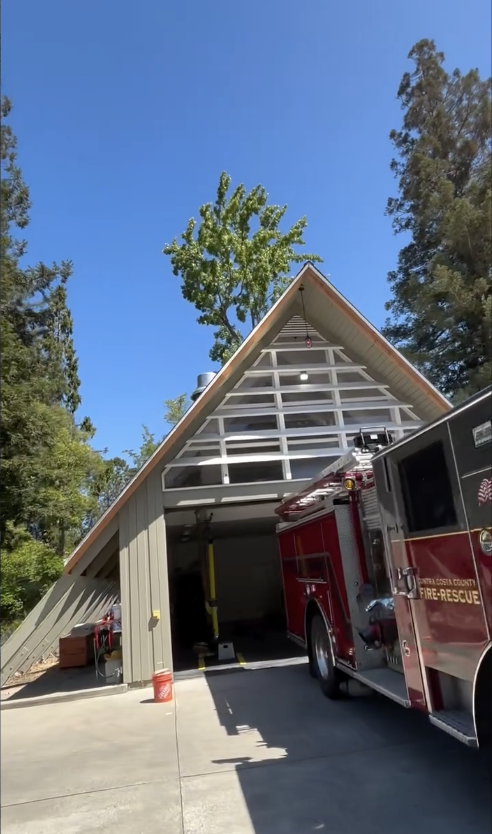 Repair on a sloped roof, under a clear blue sky, surrounded by tall trees in San Benito County. 