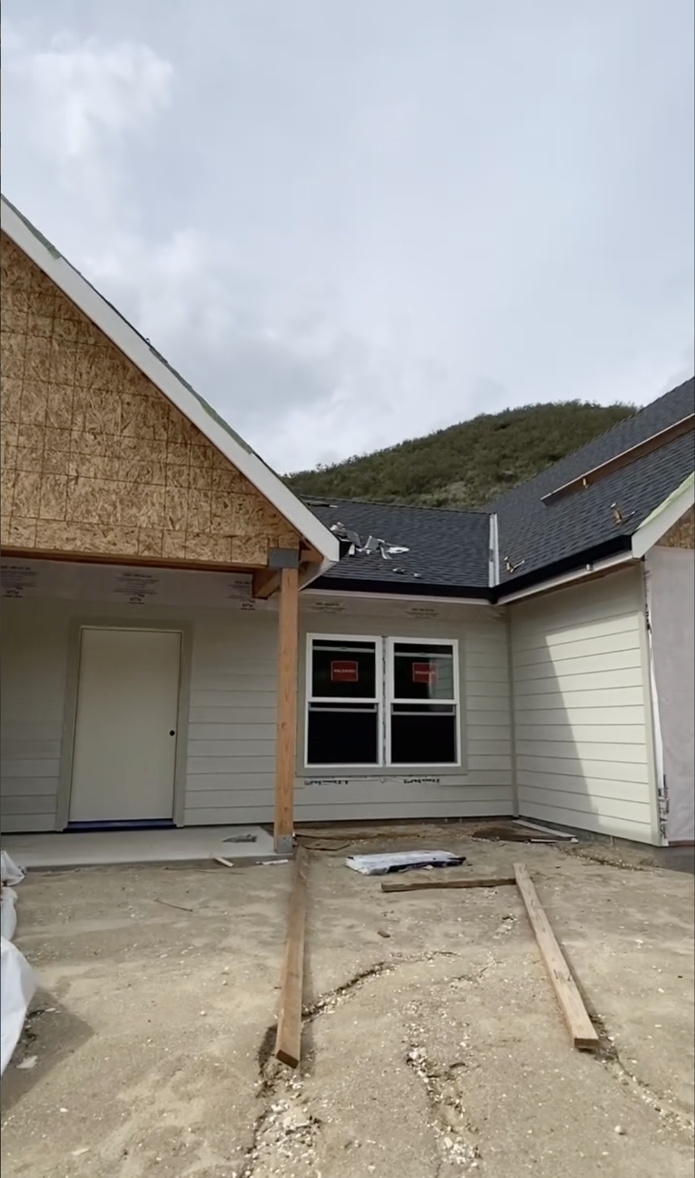 Front of a house under remodel construction with new siding, windows, and roofing being installed in Gilroy , CA. 