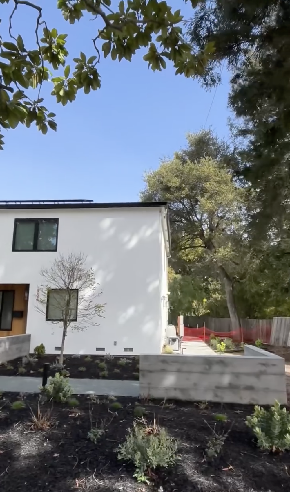 A white modern house with multiple rectangular windows with a new gutter install in San Jose, CA. 
