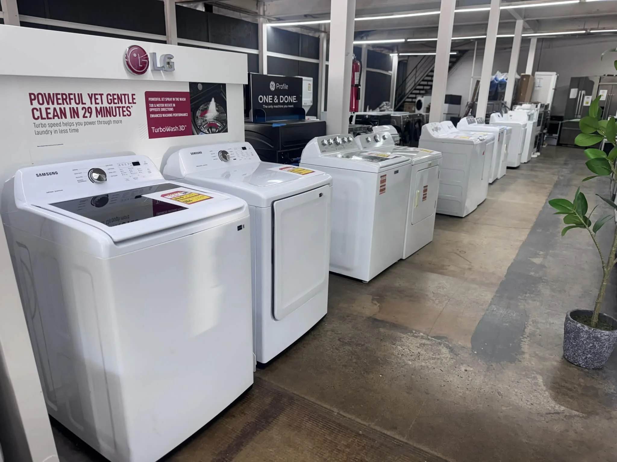A row of top load white washer dryer sets: samsung, lg, maytag, whirlpool and more on sale. Open box discount appliance outlet. 