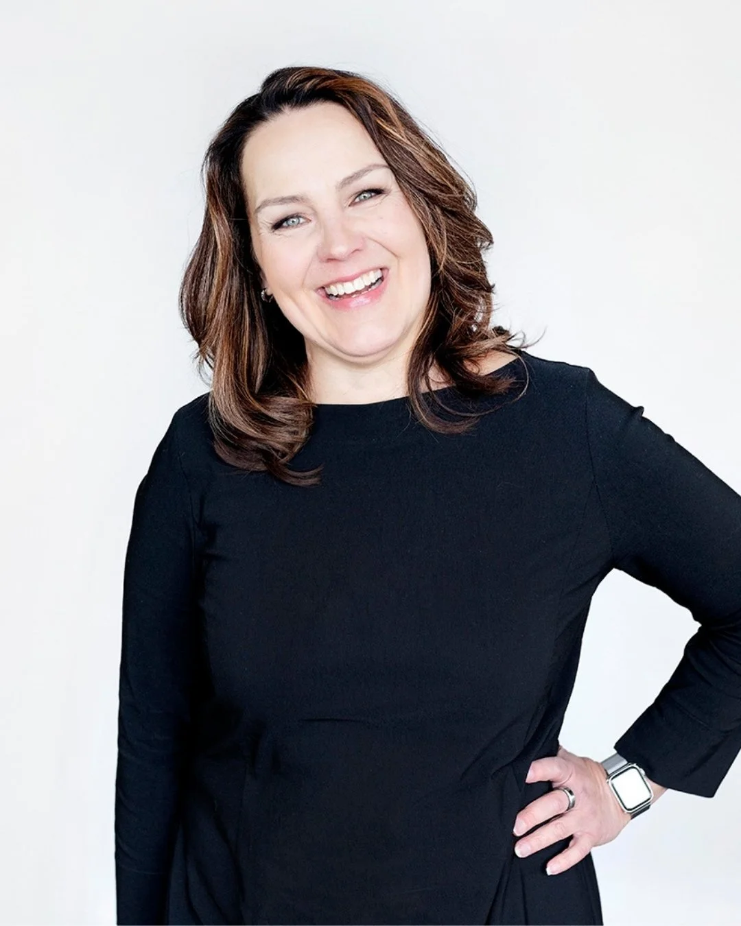 Miia seisoo käsi lanteilla ja nauraa katsoen kameraan.