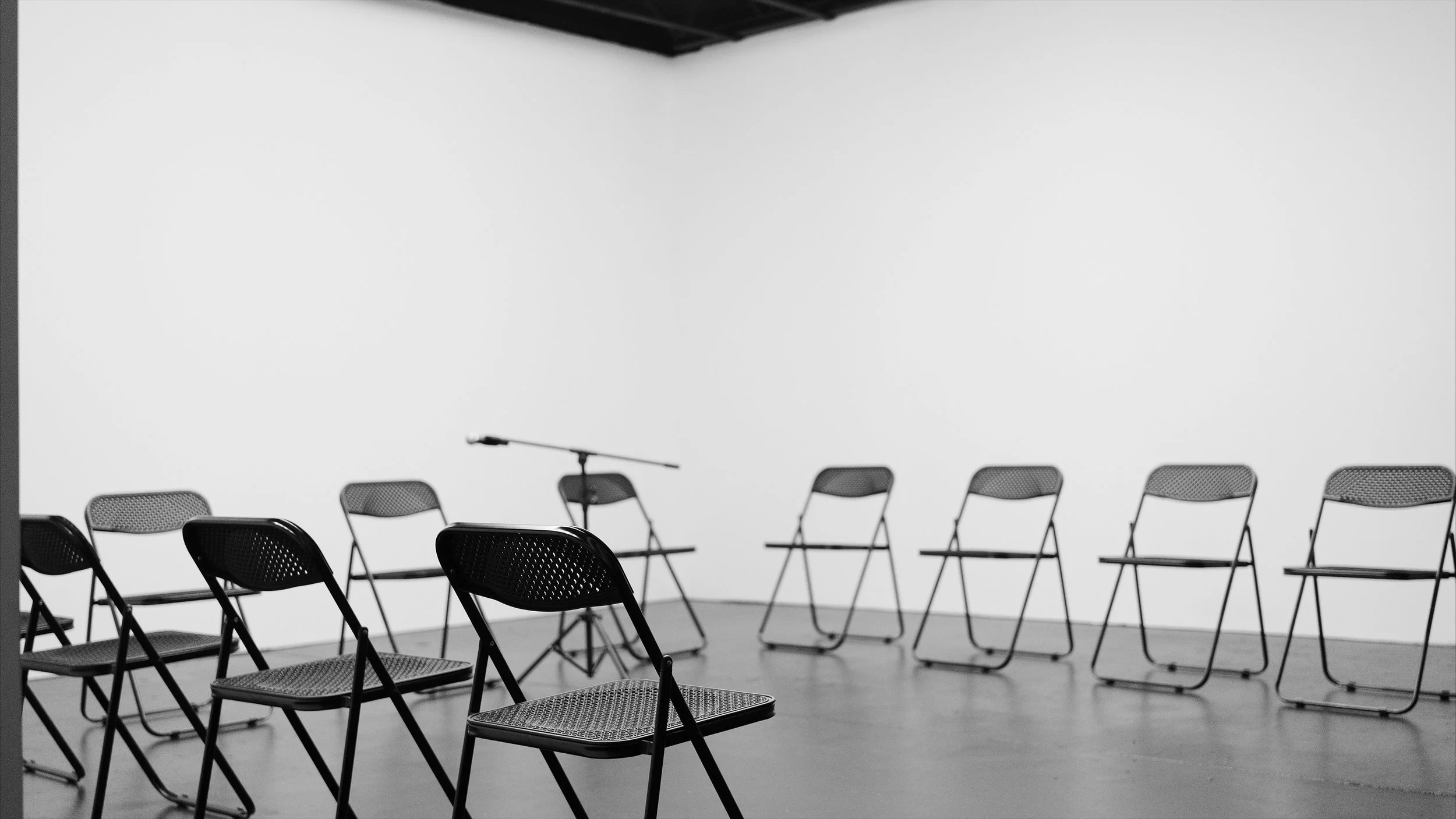 Folding chairs arranged around a microphone in the studio event space.