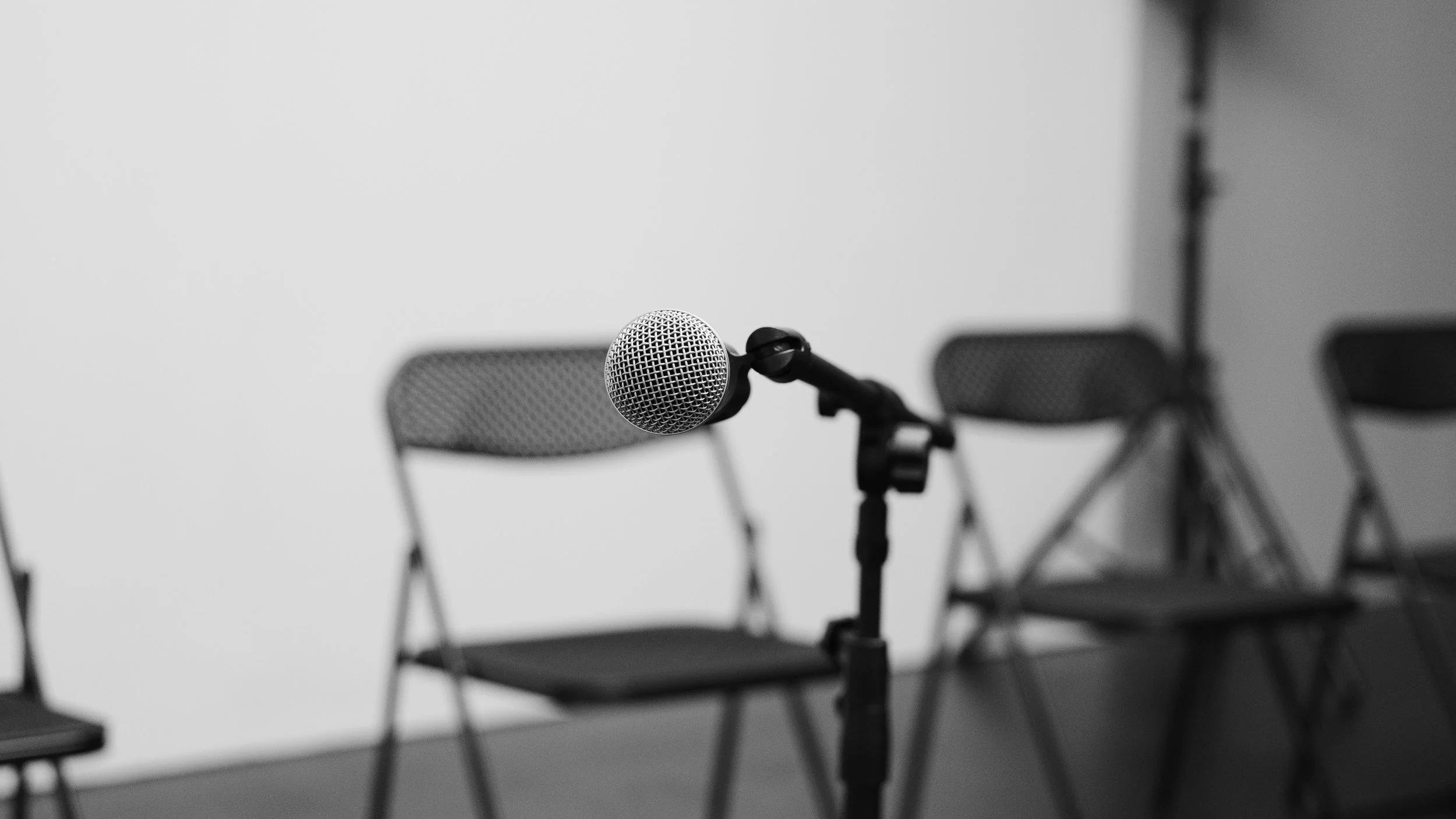 Microphone on a stand with event seating in the background.