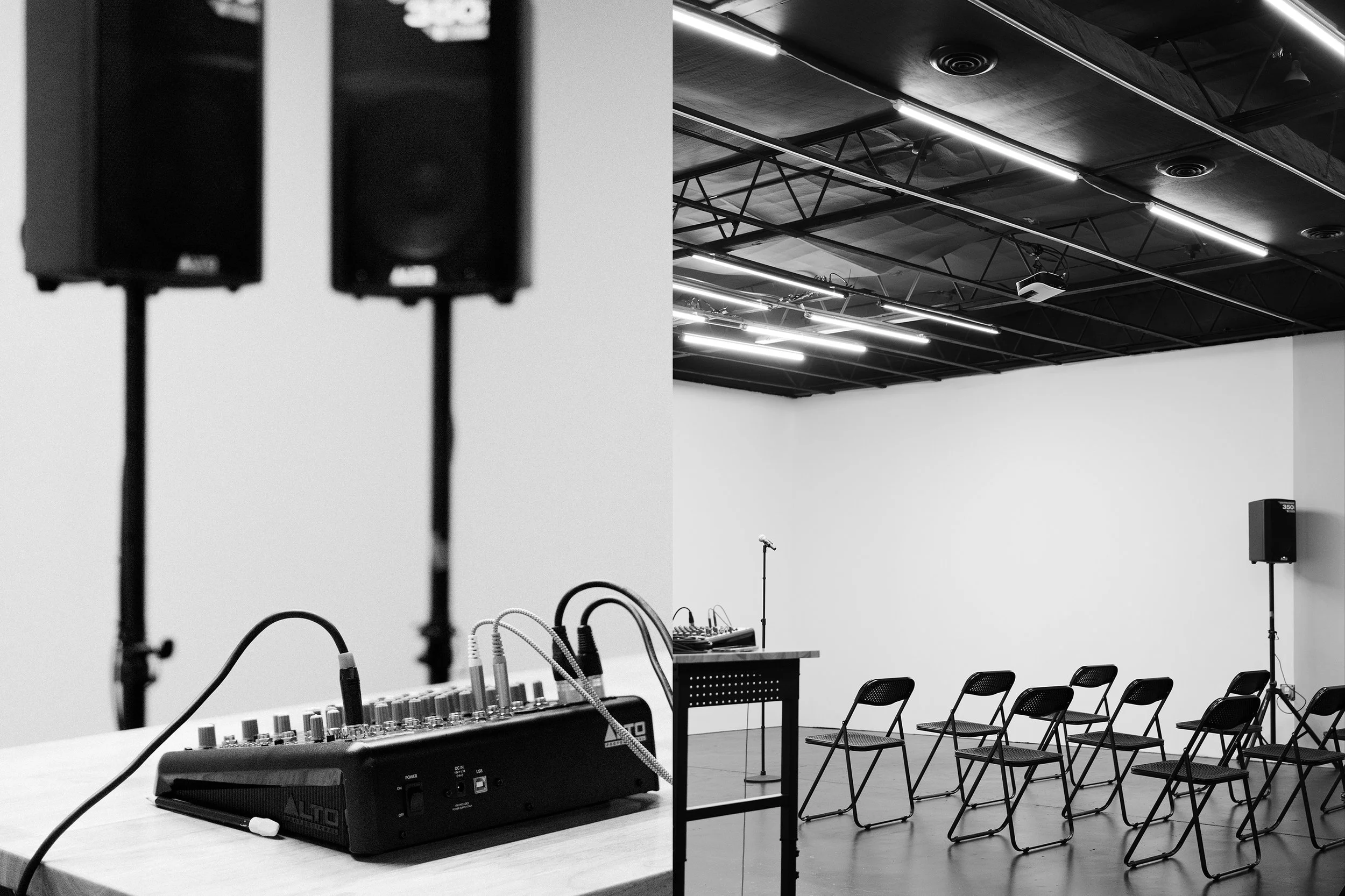 A black and white photograph of an empty event space or conference room with sound equipment, chairs, and a stage setup.