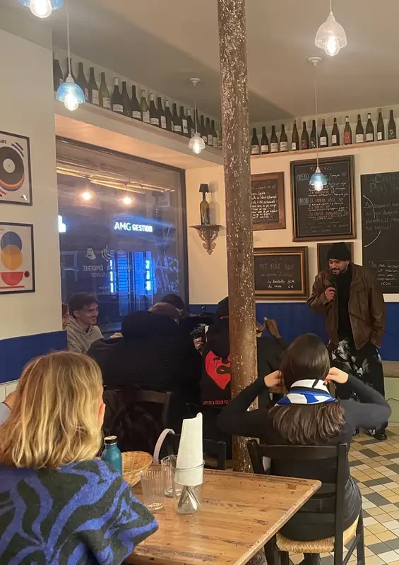 un homme qui se tient debout avec un micro devant un public 