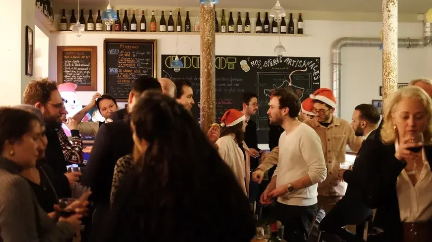 Groupe de collègue debout durant un afterwork dans un bar dans le 11ème arrondissement de Paris