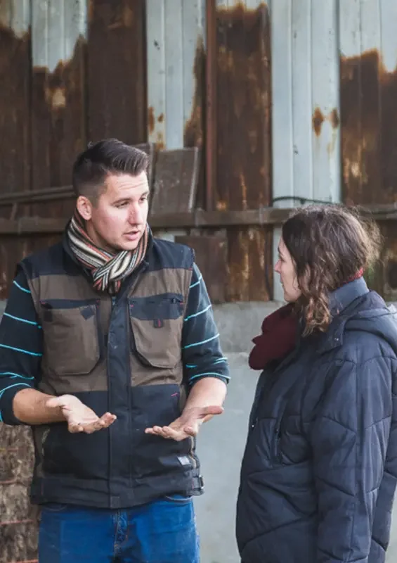 deux personnes qui discutent dans une ferme 