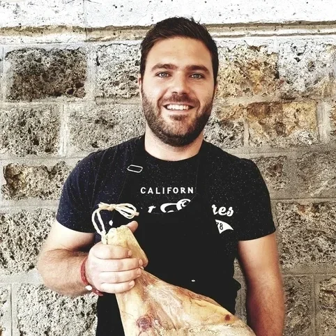 Deux chefs en cuisine préparant des courgettes fraîches et des produits locaux.