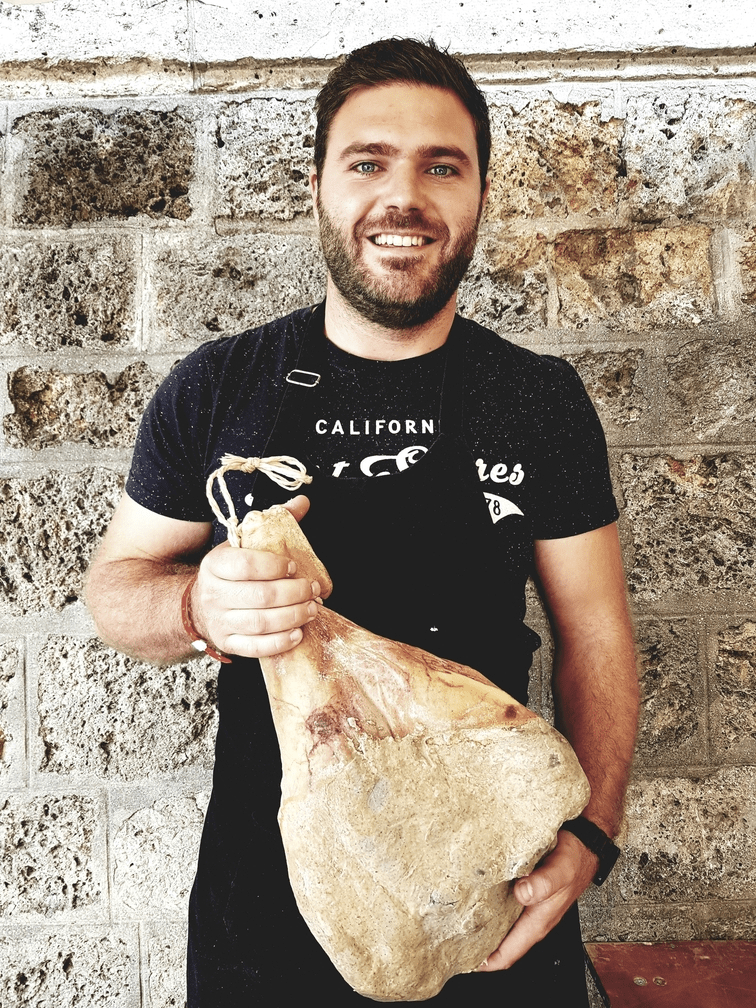 Nicolas de la Ferme de Michel tenant un jambon fermier artisanal.