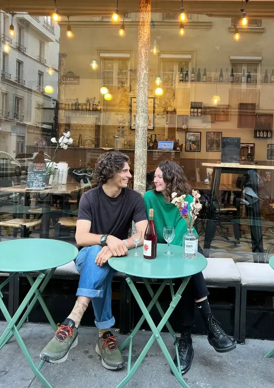 deux personnes discutant sur une terrasse  autour d'un verre 