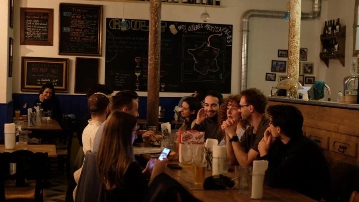 Un groupe d'amis pendant l'apéro autour une planche à partager