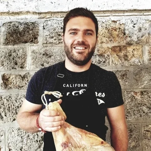 Nicolas de la Ferme de Michel tenant un jambon fermier artisanal.